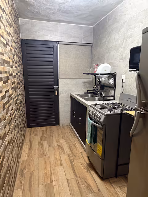 Cocina equipada con estufa de gas y refrigerador
