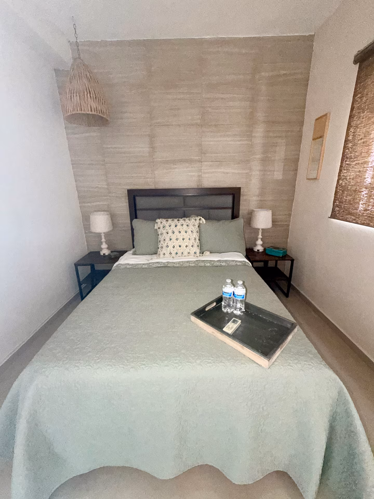 Recámara con cama matrimonial y bandeja de bienvenida en hospedaje de Guadalupe