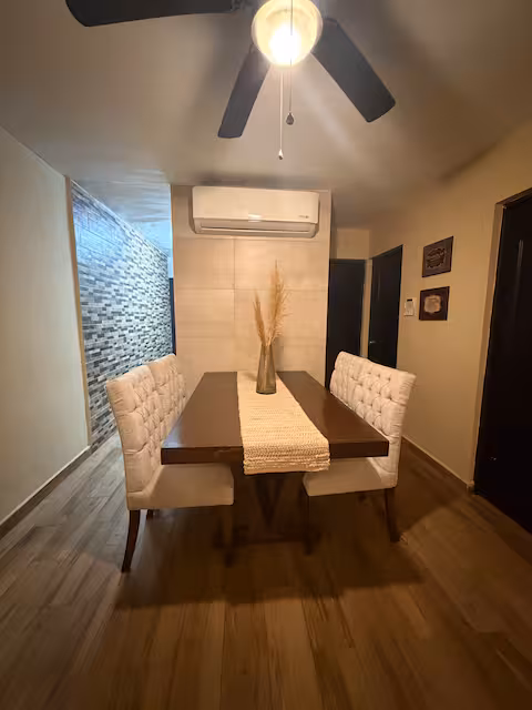 Comedor con mesa, sillas y aire acondicionado